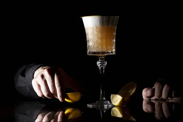 Бармен делает классический янтарный коктейль с цитрусовыми на черном фоне — стоковое фото