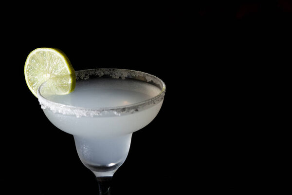 classic margarita cocktail with lime on a black background