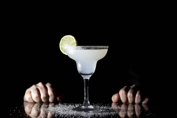 bartender serves classic margarita with lime on a black background