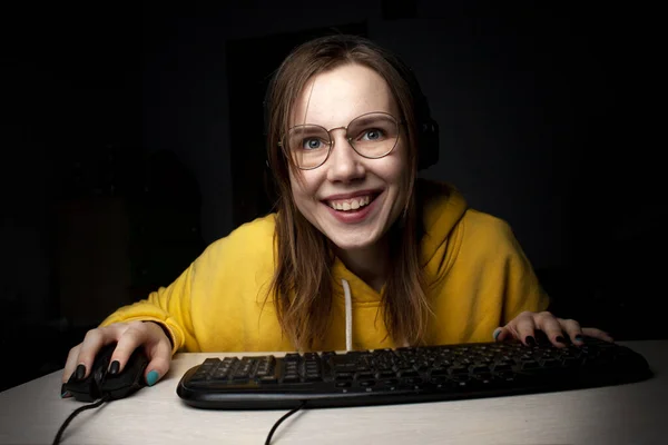 Chica gamer se sienta en un portátil en la noche en casa, un estudiante juega juegos, ella pierde y gana — Foto de Stock
