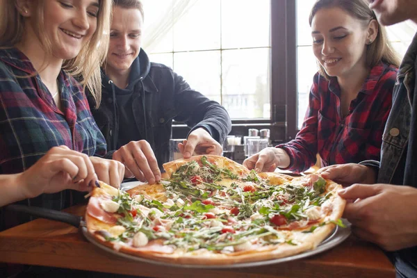 friends of classmates eat pizza in a pizzeria, students at lunch eat fast food