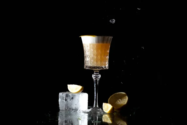 Классический янтарный коктейль с цитрусовыми и льдом на черном фоне — стоковое фото