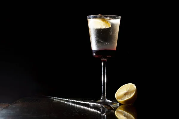 Бармен делает коктейль с шампанским в стакане на черном фоне — стоковое фото