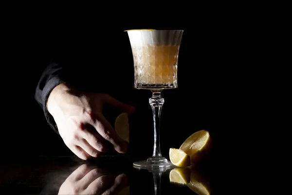 Bartender faz coquetel âmbar clássico com citrinos em um fundo preto — Fotografia de Stock