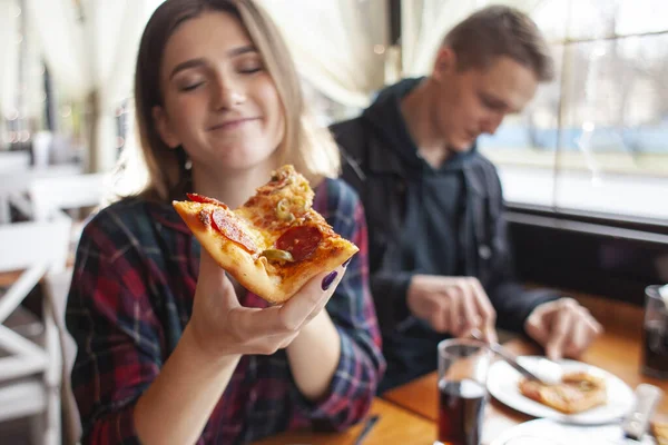 Chica joven comiendo una rebanada de pizza en el interior, estudiante chica da pizza, primer plano — Foto de Stock