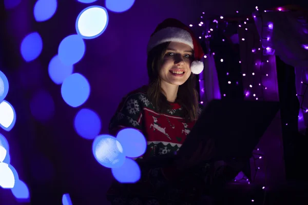 Girl student in Christmas clothes sits at home with a laptop at night, a lonely woman meets a holiday online, she use a computer for Christmas — Stock Photo, Image