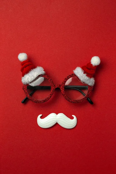 Fond rouge de Noël avec des lunettes de Père Noël et moustache blanche hipster. Symboles de Noël et décorations du Nouvel An — Photo