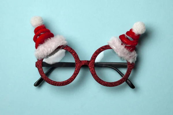 Gafas de Año Nuevo con estilo de Santa sobre un fondo azul, símbolo de Navidad — Foto de Stock