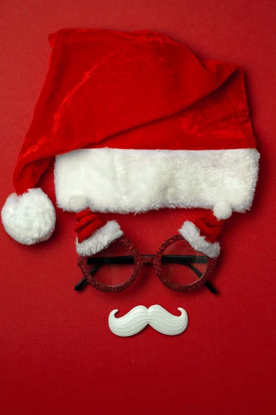 Fondo rojo de Navidad con gafas de Santa Claus y bigote hipster blanco. Símbolos de Navidad y decoraciones de Año Nuevo —  Fotos de Stock