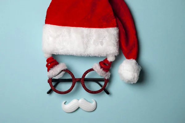 Świąteczne tło z okularami Mikołaja i białymi hipsterskimi wąsami. Symbole bożonarodzeniowe i dekoracje noworoczne, płaskie świeckie — Zdjęcie stockowe