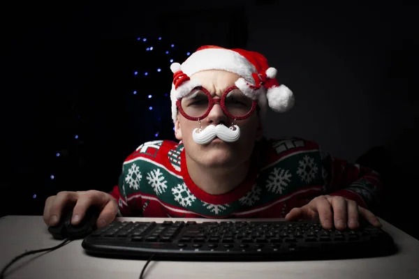 guy plays on a computer in the New Year at night, a lonely student gamer at Christmas sits near a computer