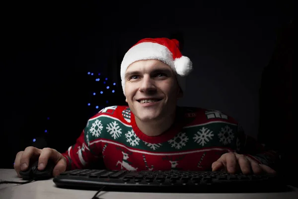 guy plays on a computer in the New Year at night, a lonely student gamer at Christmas sits near a computer