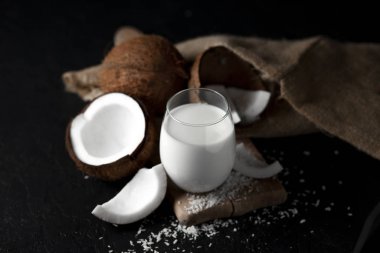 Bir bardakta taze hindistan cevizi sütü koyu bir arka plan, Hindistan cevizi kozmetik kreması, hindistan cevizi dilimli milkshake.