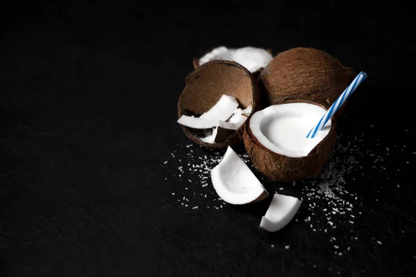Natuurlijke verse kokosmilkshake op een donkerzwarte achtergrond, melk in een bord kokosnoot — Stockfoto