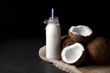 Siyah arka planda hindistan cevizi sütü, siyah masada hindistan cevizi milkshake.