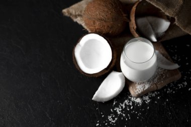 Bir bardakta taze hindistan cevizi sütü koyu bir arka plan, Hindistan cevizi kozmetik kreması, hindistan cevizi dilimli milkshake.