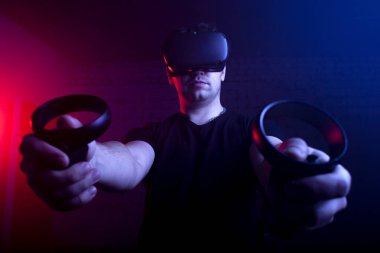 Sanal gerçekliğin kablosuz gözlüklü bir oyuncu tetikçiyi oynar, bir adam karanlık bir odada 3 boyutlu bir oyuna odaklanır.