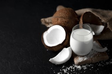 Bir bardakta taze hindistan cevizi sütü koyu bir arka plan, Hindistan cevizi kozmetik kreması, hindistan cevizi dilimli milkshake.