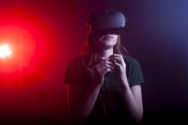 Gece oyun odasında sanal gerçeklik gözlüklü bir kız. Sanal uzayda bir kadın.