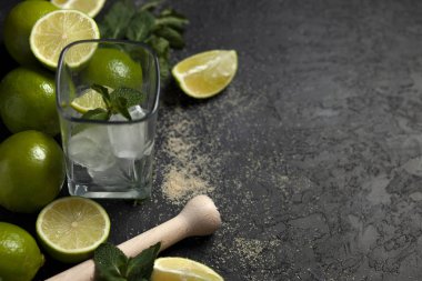 Ev yapımı kokteyl hazırlama süreci, siyah arka planda mojito malzemeleriyle dolu, ferahlatıcı bir yaz kokteyli.