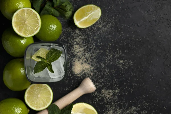 Processo di preparazione di cocktail fatti in casa, piatto con gli ingredienti per il mojito su fondo nero, un rinfrescante cocktail estivo — Foto Stock