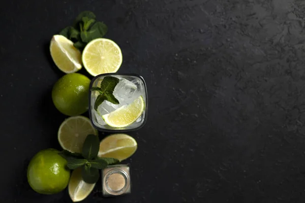 Processo di preparazione di cocktail fatti in casa, piatto con gli ingredienti per il mojito su fondo nero, un rinfrescante cocktail estivo — Foto Stock