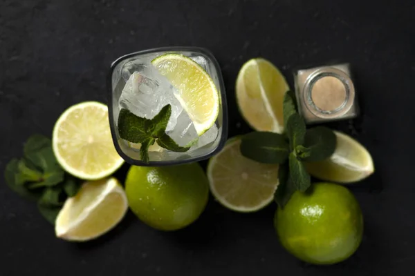 Processo di preparazione di cocktail fatti in casa, piatto con gli ingredienti per il mojito su fondo nero, un rinfrescante cocktail estivo — Foto Stock