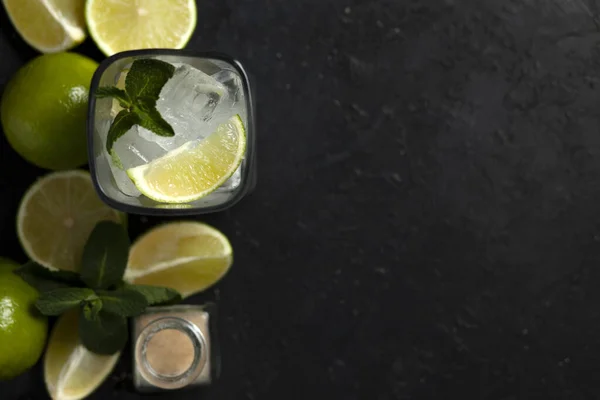 Processo di preparazione di cocktail fatti in casa, piatto con gli ingredienti per il mojito su fondo nero, un rinfrescante cocktail estivo — Foto Stock