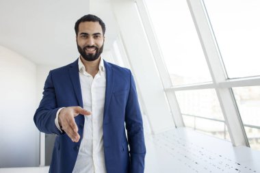 Takım elbiseli bir ofis çalışanı iş bulur, elini uzatır ve gülümser, çalışanları işe alır, patronlarla görüşür.