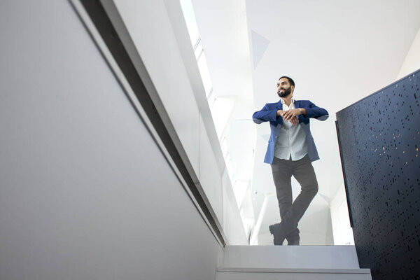 The head of the company stands in a white office and looks out the window, a successful businessman finding employment in a large company, copy space