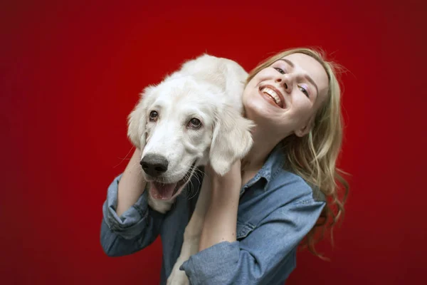 배경에 황금색 리트리버 강아지를 아름다운 소녀가 웃으며 강아지를 가까이 — 스톡 사진