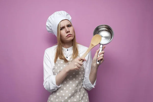 Serieus Meisje Kok Keuken Kleding Houdt Gerechten Een Roze Achtergrond — Stockfoto