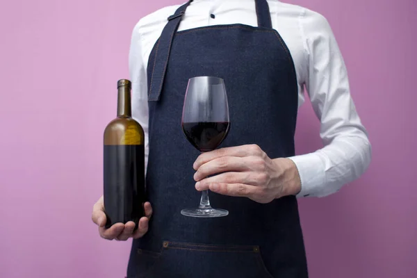 Νεαρός Επαγγελματίας Σερβιτόρος Στολή Κρατά Ένα Μπουκάλι Κόκκινο Κρασί Και — Φωτογραφία Αρχείου