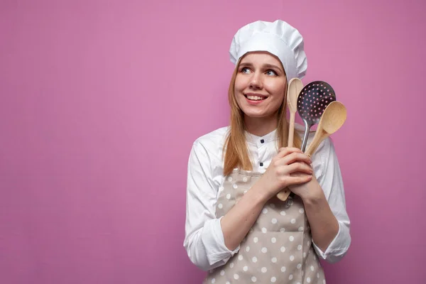 Młoda Wesoła Dziewczyna Gotować Fartuchu Posiada Łyżki Przedmioty Kuchenne Marzenia — Zdjęcie stockowe