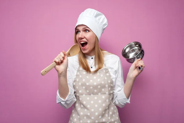 Engraçado Menina Bonita Cozinheiro Avental Detém Pratos Canta Fundo Rosa — Fotografia de Stock
