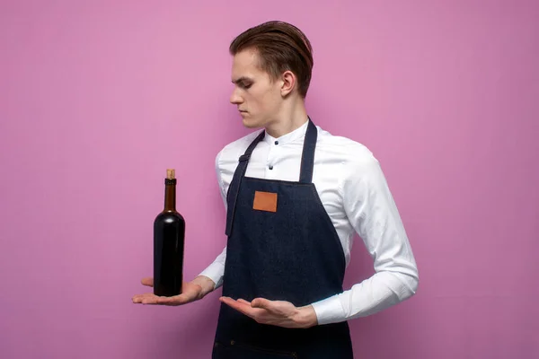 Joven Sommelier Chico Sostiene Una Botella Vino Tinto Sobre Fondo — Foto de Stock