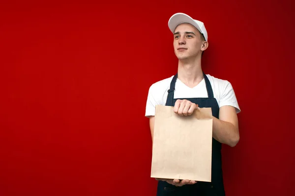 Mensajero Joven Uniforme Sostiene Paquete Mira Lugar Para Texto Repartidor — Foto de Stock