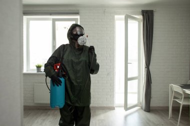 Dairede koronavirüs dezenfeksiyonu. Koruyucu giysili insanlar odayı virüslerden ve hastalıklardan, enfeksiyon temizleme servisinden profesyonel olarak temizliyorlar.