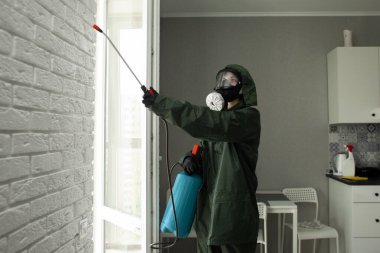 Evin içinde koronavirüs dezenfeksiyonu. Tehlikeli maddedeki dezenfektan daireyi virüslerden ve enfeksiyonlardan antibakteriyel spreyle temizliyor.