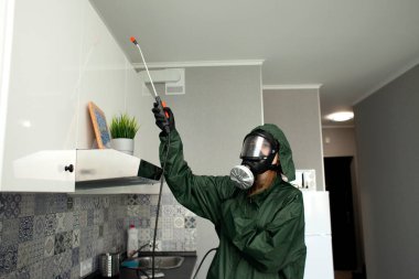 Dairede koronavirüs dezenfeksiyonu. Koruyucu giysili insanlar odayı virüslerden ve hastalıklardan, enfeksiyon temizleme servisinden profesyonel olarak temizliyorlar.