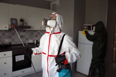 Evin içinde koronavirüs dezenfeksiyonu. Tehlikeli maddedeki dezenfektan daireyi virüslerden ve enfeksiyonlardan antibakteriyel spreyle temizliyor.