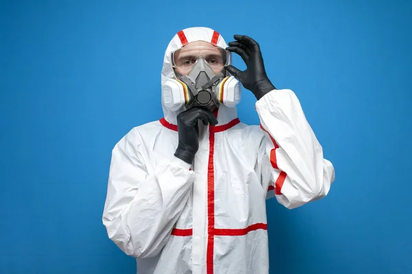 防護服を着たプロの消毒師がマスクと眼鏡をかけて青い隔離された背景に消毒サービス労働者コロナウイルスの概念 — ストック写真