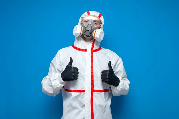 防護服を着た専門家の消毒担当者は青い隔離された背景 消毒サービスワーカー コロナウイルスの概念のようなものを示しています — ストック写真