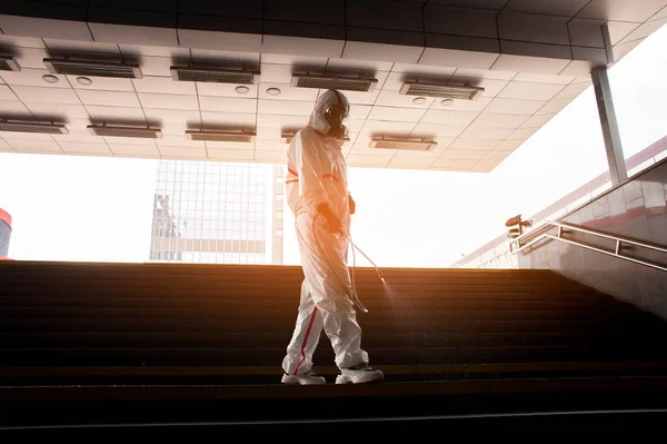 Coronavirus pandemic. disinfection service worker in a protective suit cleans the streets of the city from virus and infection with chemicals, city isolation