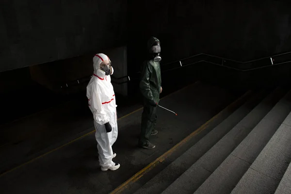 コロナウイルスのパンデミック 防護服を着た消毒サービス労働者が街の通りをウイルスから清掃し化学物質で感染させ街を隔離する — ストック写真