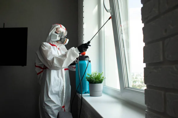 防護服を着た男が化学薬品で感染症のアパートをきれいにしアパートで衛生的な仕事をしドライクリーニング — ストック写真