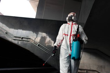 Dezenfeksiyon işçisi, koruyucu giysili adam ve solunum cihazı, şehir dezenfeksiyonu, kimyasal tedavi