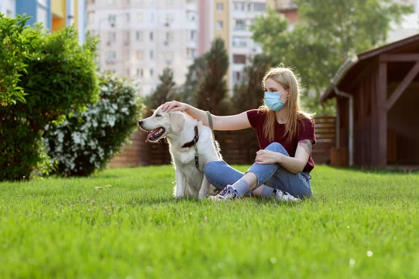 코로나 바이러스 대유행 보호용 마스크를 소녀가 공원에서 산책하고 검역중인 강아지를 — 스톡 사진