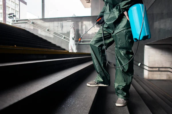 disinfection of the city. a man in a protective suit cleans the steps with a chemical agent, closeup