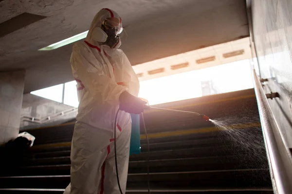 Coronavirus pandemic. disinfection service worker in a protective suit cleans the streets of the city from virus and infection with chemicals, city isolation